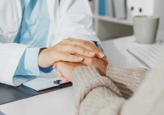 A health care provider holding a patients hand.