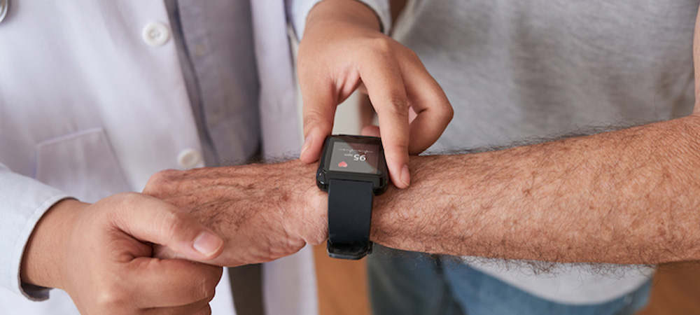 A doctor reviewing the heart rate of patient on a watch.