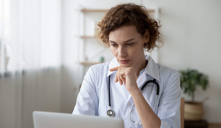 A health care provider looking at a laptop.