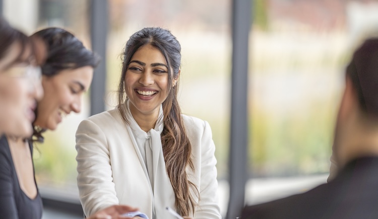 A woman laughing with a colleague.