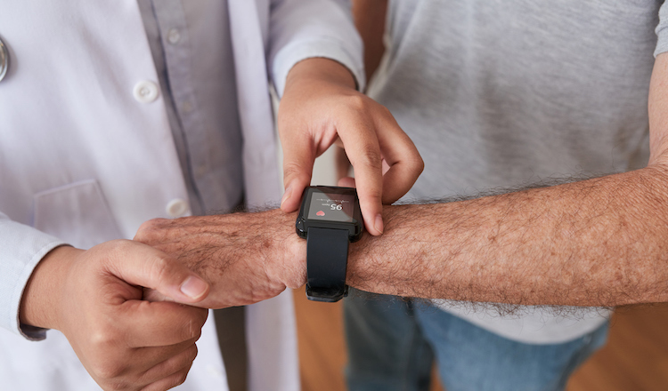 A doctor looking at patient's heart rate on a watch. 