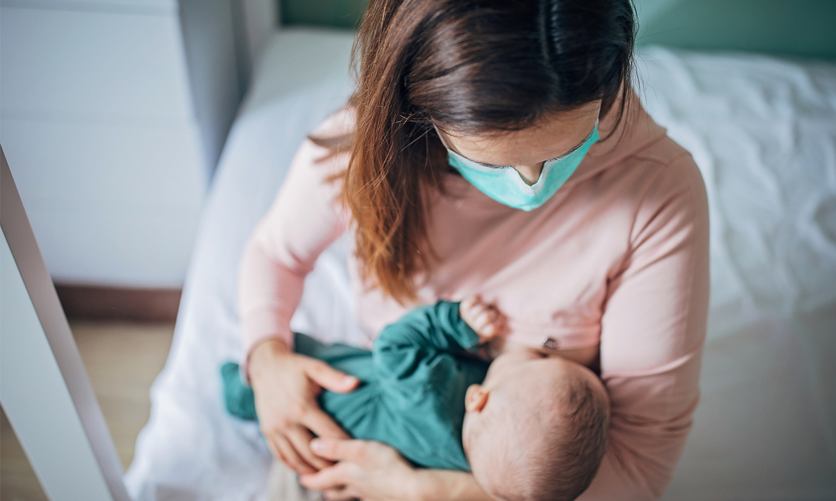 Woman breastfeeding with a mask on