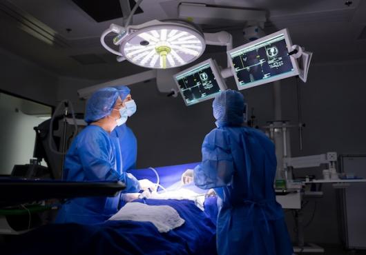 Three surgeons operating on a patient.