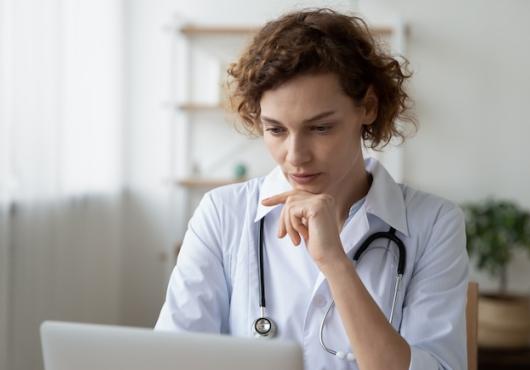 A health care provider looking at a laptop.
