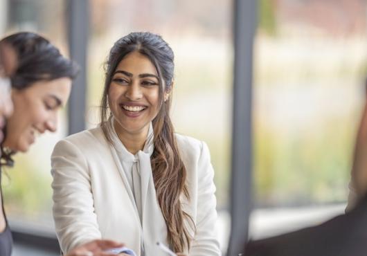 A woman laughing with colleagues.