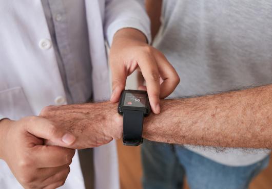 A doctor observing the heart rate of a patient through a watch. 