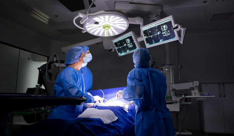 Three surgeons operating on a patient.