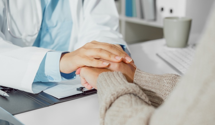 A health care provider holding a patients hand.