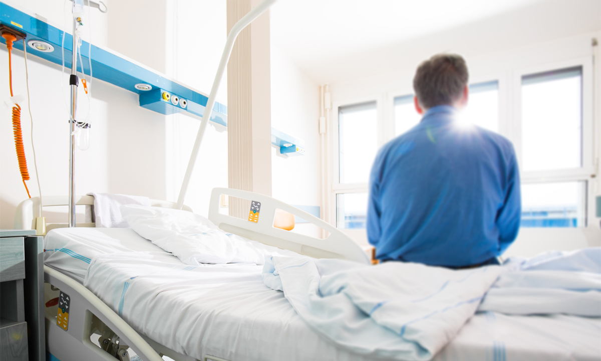 Male patient sitting on a hospital bed