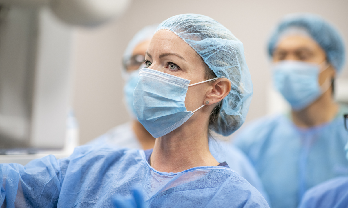 Female surgeon in surgical gown and mask